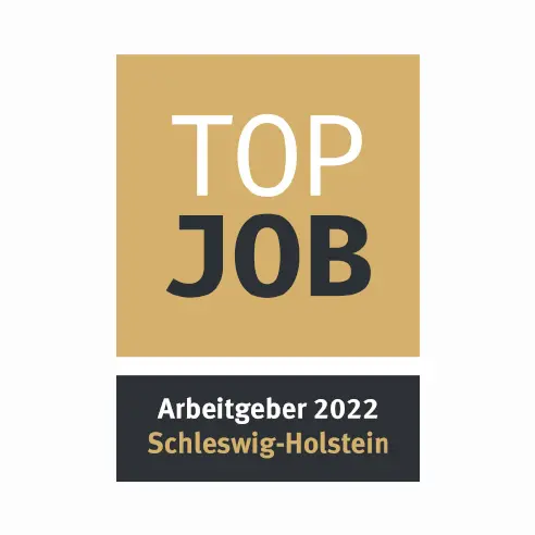 The image features a logo that reads "TOP JOB" in bold letters, indicating a high-quality employer recognition. Below, it states "Arbeitgeber 2022 Schleswig-Holstein," designating the award year and region. The logo uses a gold and black color scheme.