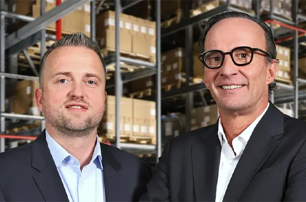 Geschäftsführer von Queisser Pharma in Anzügen vor einem Hochregallager