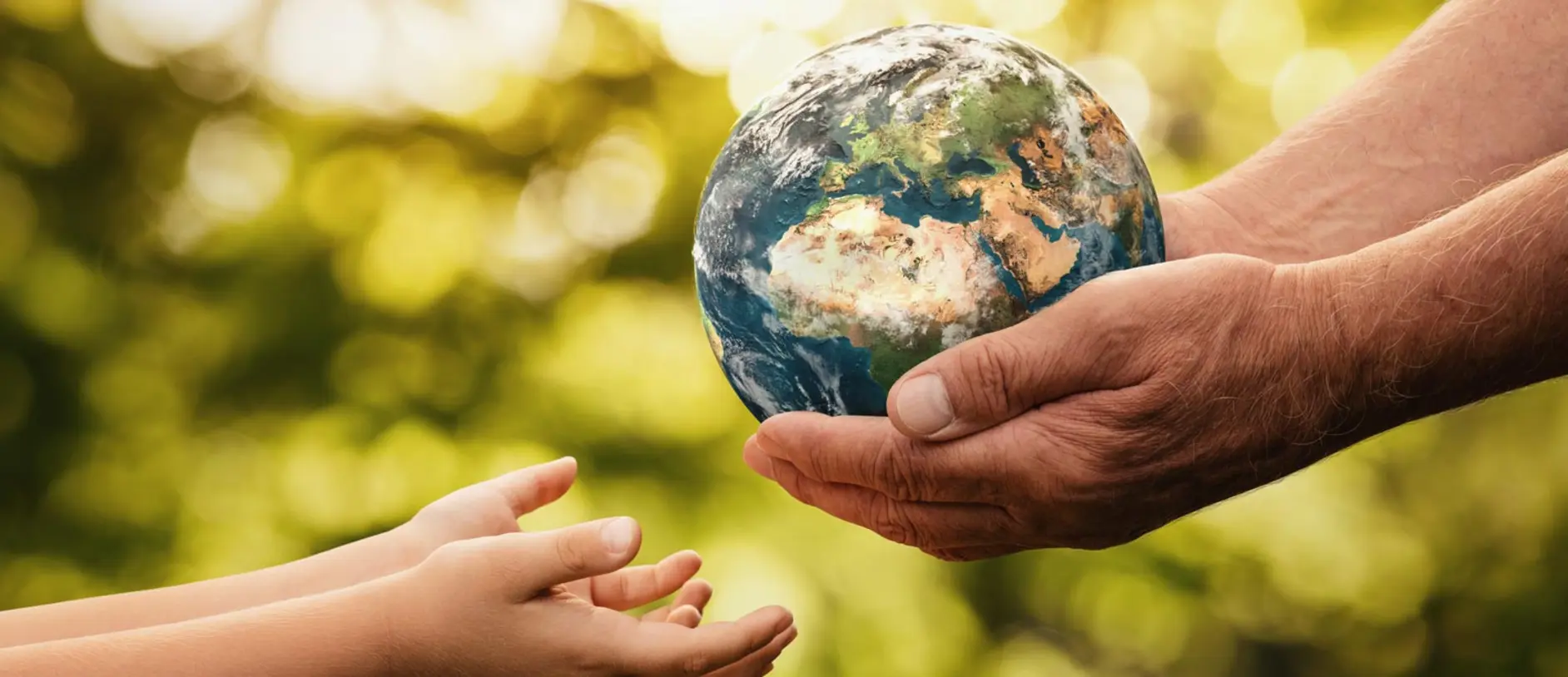 An elderly hand holds a small globe, symbolizing Earth, while a child's hands reach out towards it. The background is softly blurred with greenery, emphasizing the connection between generations and the importance of caring for the planet.